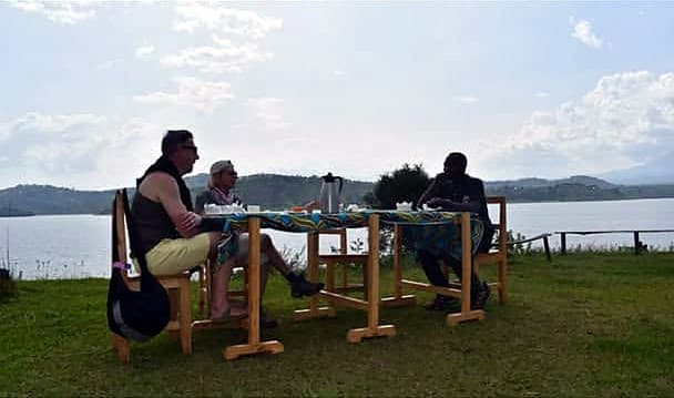 Guests and guide at a lakeside lunch table